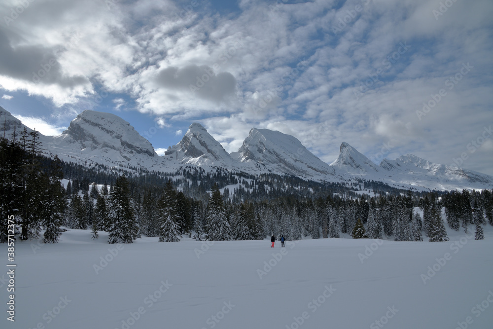 Naklejka premium Wanderer vor den winterlichen Churfirsten Gipfel in der Schweiz