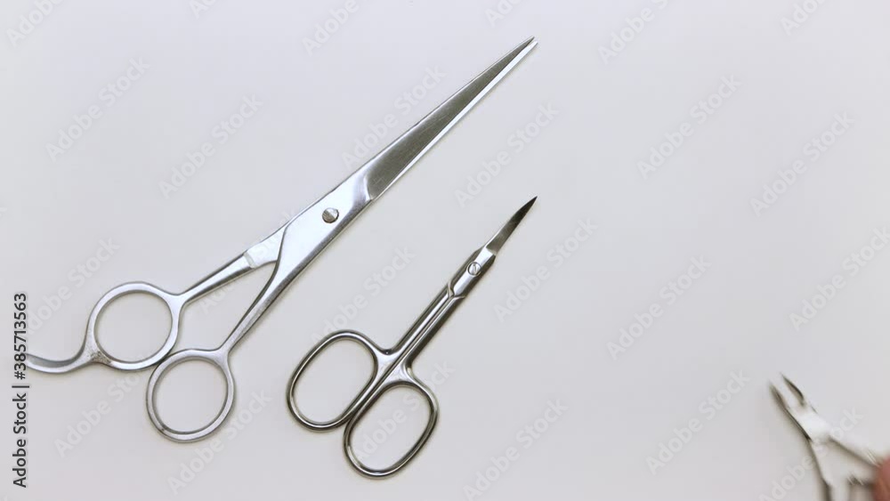 A man's hand removes large, small scissors and wire cutters from the table. We do the manicure ourselves. Self-care nails. Isolated video on a white background. Close-up. Warm, soft light. UHD. A man's hand removes large, small scissors and wire cutters from the table. We do the manicure ourselves. Self-care nails. Isolated video on a white background. Close-up. Warm, soft light. UHD.