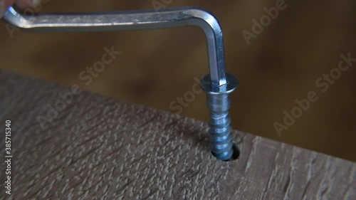 Close Up Of Tools Screwdriver Turning A Screw. Man Putting Together Self Assembly Furniture In New Home.