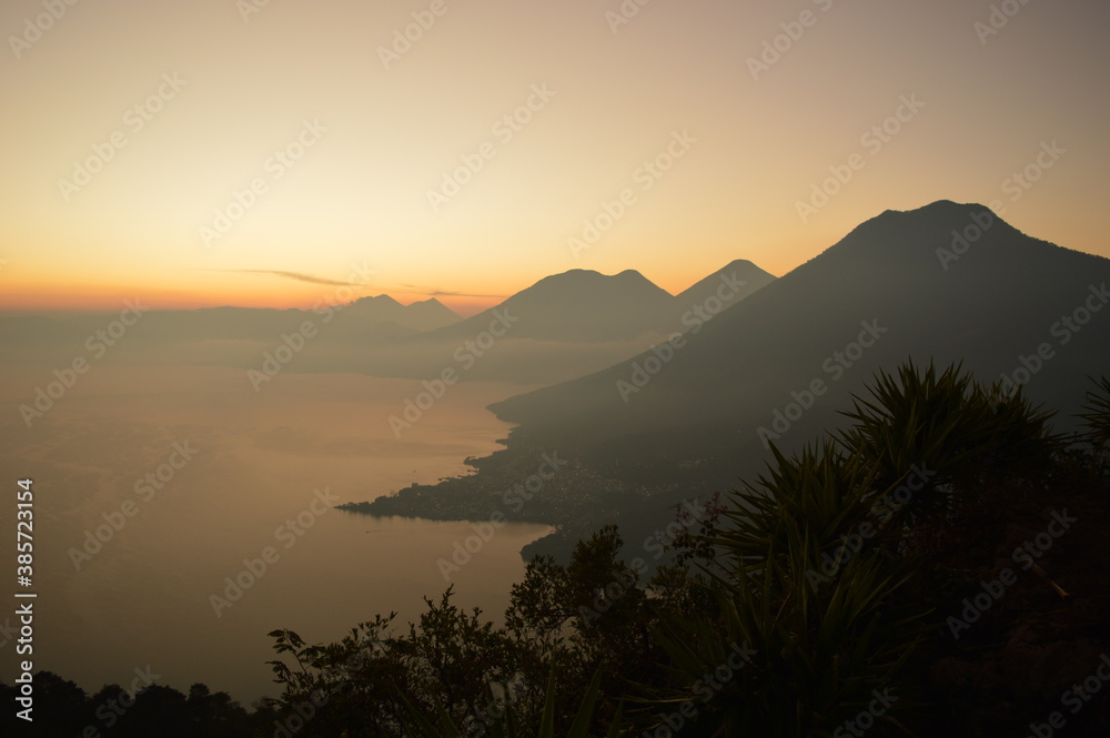 Obraz premium Sunrise over the volcanoes of Lake Atitlan in Guatemala, Central America