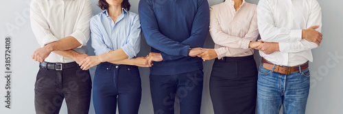 Fotografie Company coworkers holding hands ready to guard company interests and support eac