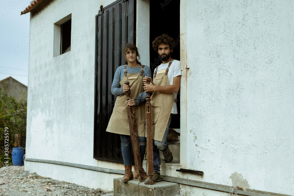 Young couple of carpenter working and crafting with wood in a workshop building furniture for interior design. Young couple entrepreneurs running a small business in a carpentry. Business people. Young couple of carpenter working and crafting with wood in a workshop building furniture for interior design. Young couple entrepreneurs running a small business in a carpentry. Business people.
