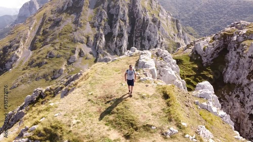 man reaching a mountain summit in the basque country (aerial orbital shot with drone) photo