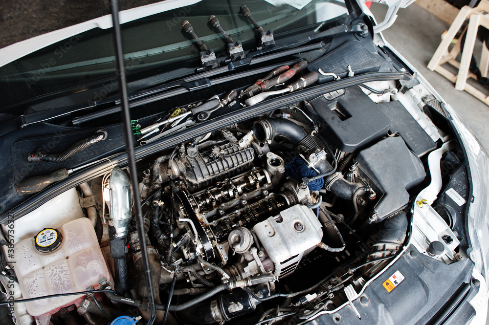 Car repair and maintenance theme. Open hood engine in auto service. Car repair and maintenance theme. Open hood engine in auto service.