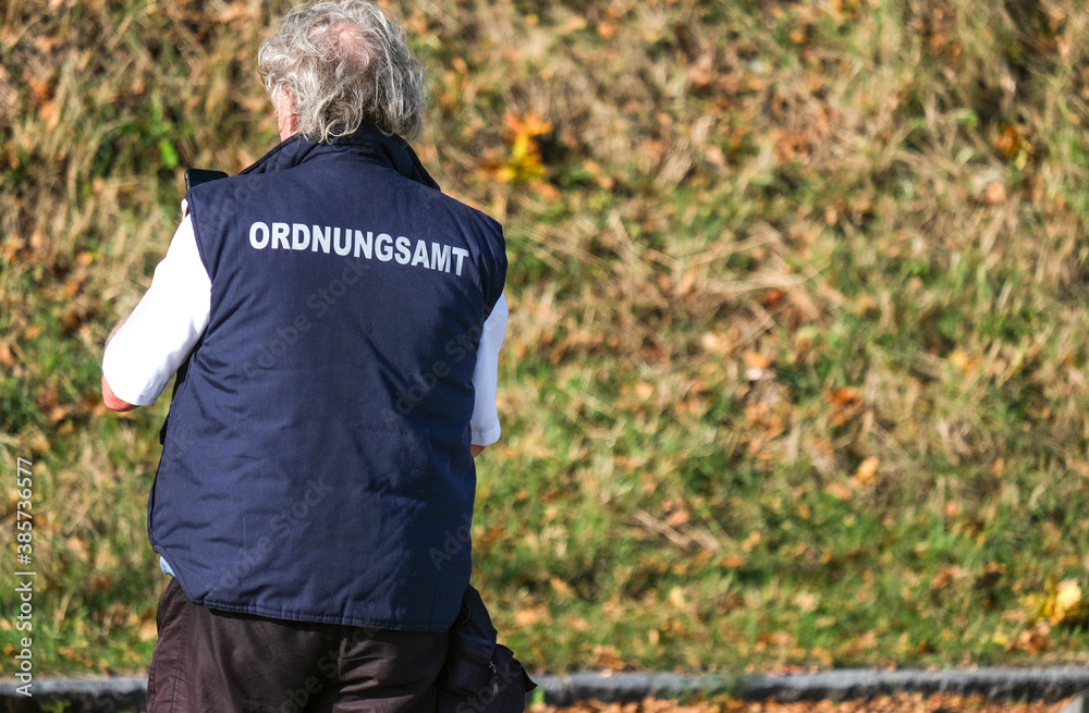 Naklejka premium Konzept Ordnung und Sicherheit: Mitarbeiter des Ordnungsamtes auf Streife und kontrolliert - selektiver Fokus, sehr viel Copyspace