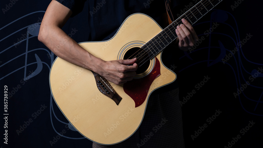 Obraz premium Musician with an acoustic guitar in the dark, Night photo with side lighting.