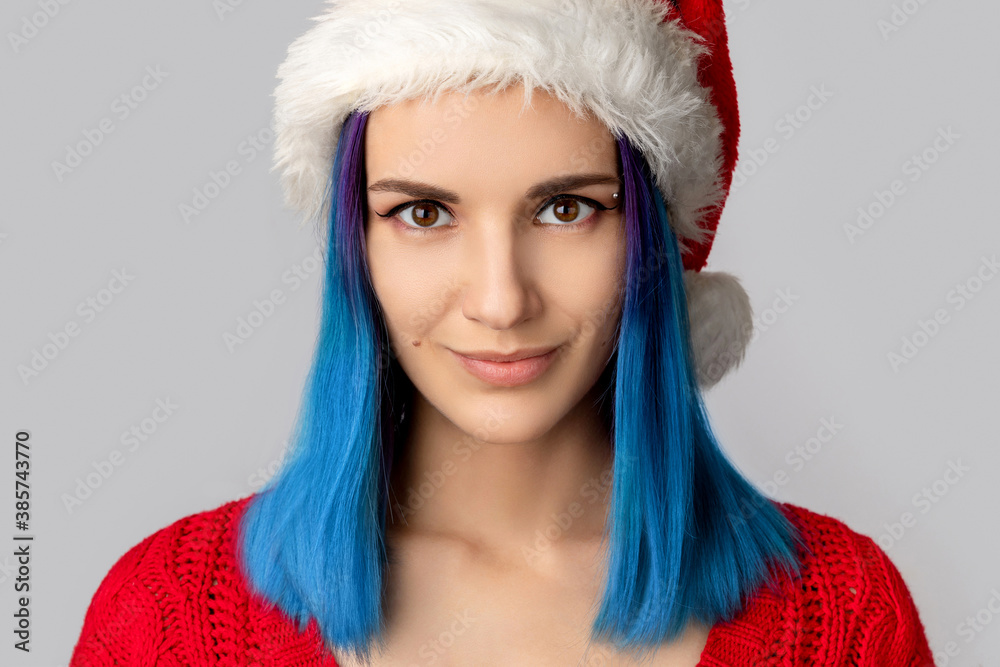 Beautiful happy young woman in santa hat over gray background Beautiful happy young woman in santa hat over gray background