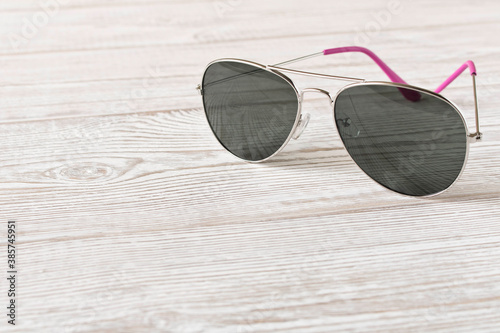 Sunglasses on a wooden table. Close up.