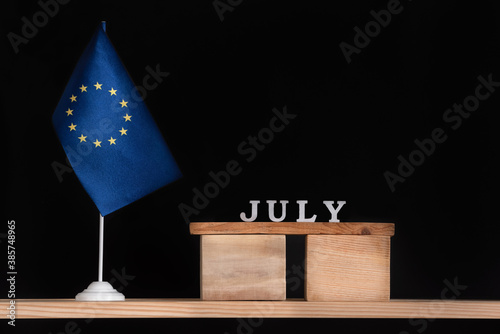 Wooden calendar of July with flag EU on black background. Holidays of European Union in July