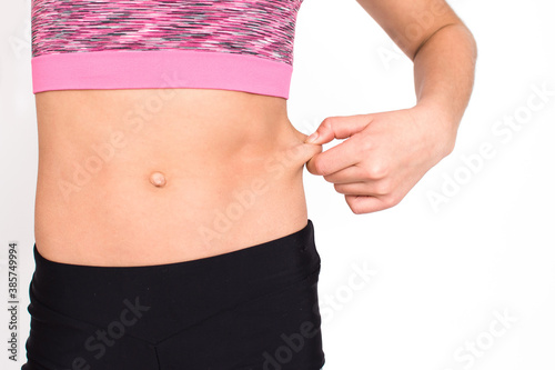 Slim young girl waist isolated on white background. Female person body in sportswear have calories loss and fat loss. Health and diet concept with copy space.