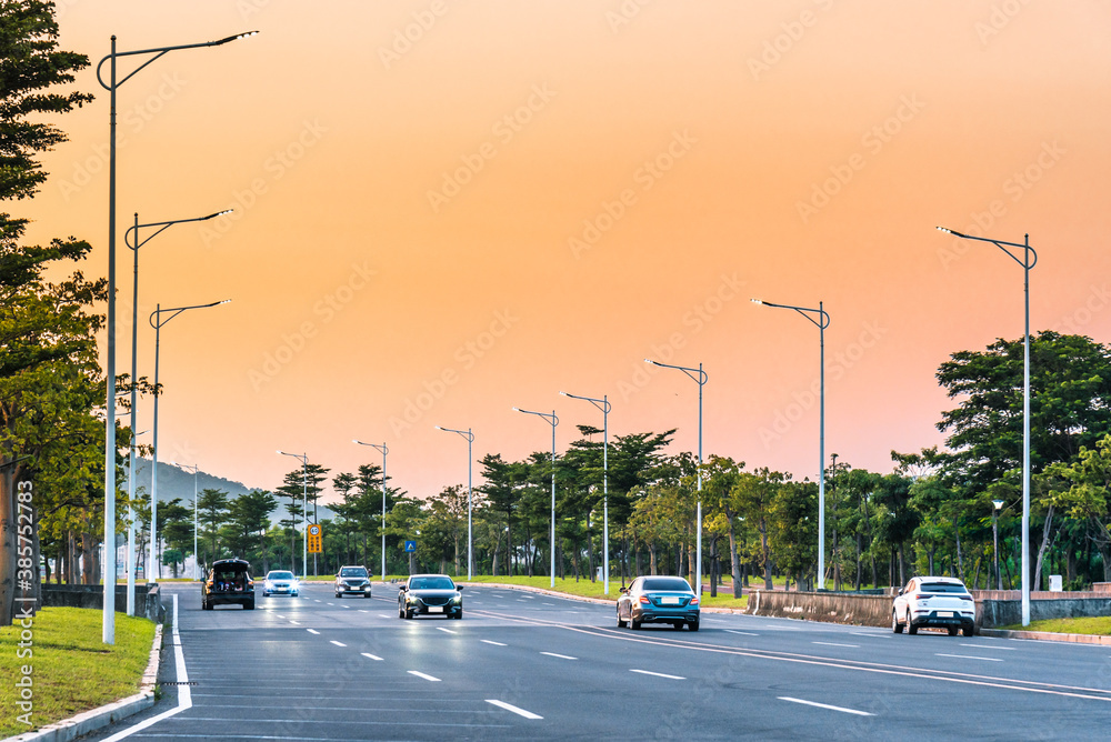 Cars driving on the city road at dawn