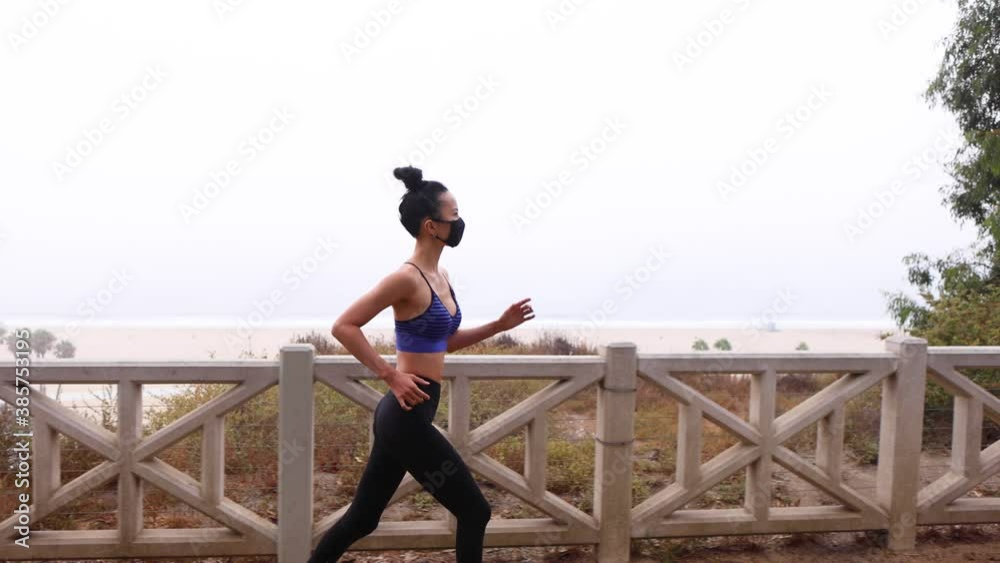 Athletic Asian woman going for her morning workout while wearing her ice mask. Foggy morning in Santa Monica California. Athletic Asian woman going for her morning workout while wearing her ice mask. Foggy morning in Santa Monica California.