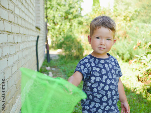 portrait of a toddler boy with a butterfly net in his hands. photo