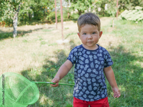 Little explorer with a butterfly net in his hands. photo