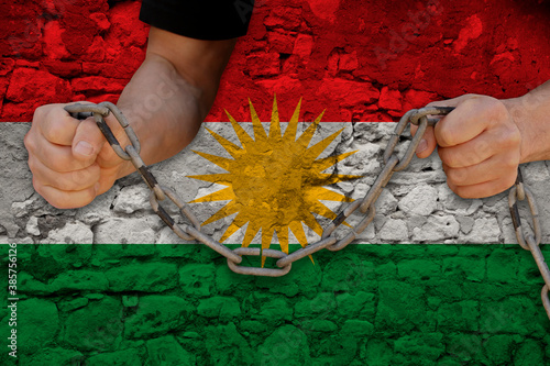 male hands breaking the iron chain, symbol of tyranny, protest against the background of the national flag Kurdistan, rojava, the concept of political repression, arrest, crime, civil rights, freedom photo