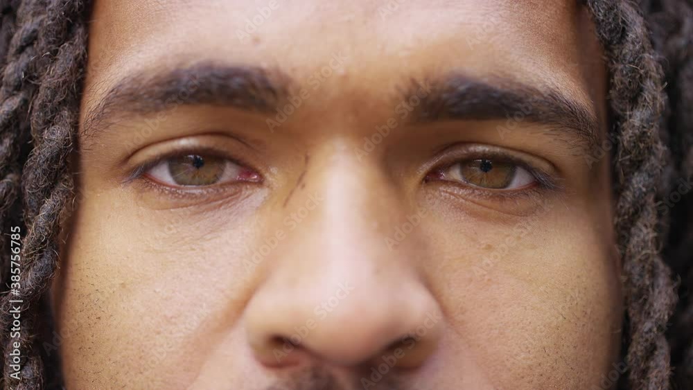 Close up shot of black man opening his eyes and staring to camera 