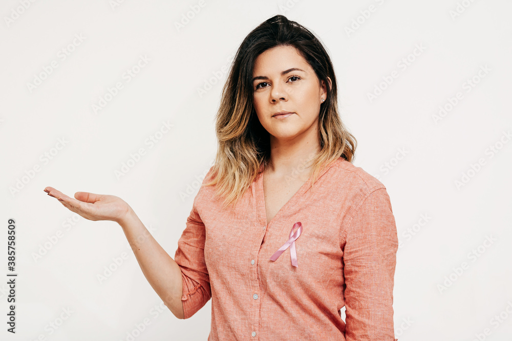 Healthcare and medicine concept - woman with pink breast cancer awareness ribbon Healthcare and medicine concept - woman with pink breast cancer awareness ribbon