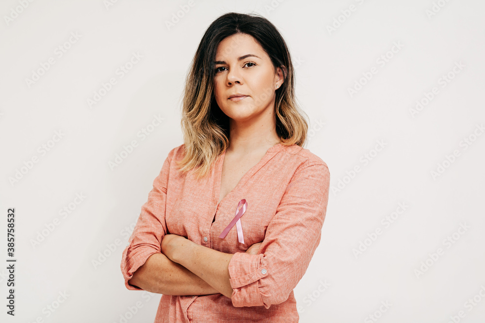 Healthcare and medicine concept - woman with pink breast cancer awareness ribbon Healthcare and medicine concept - woman with pink breast cancer awareness ribbon
