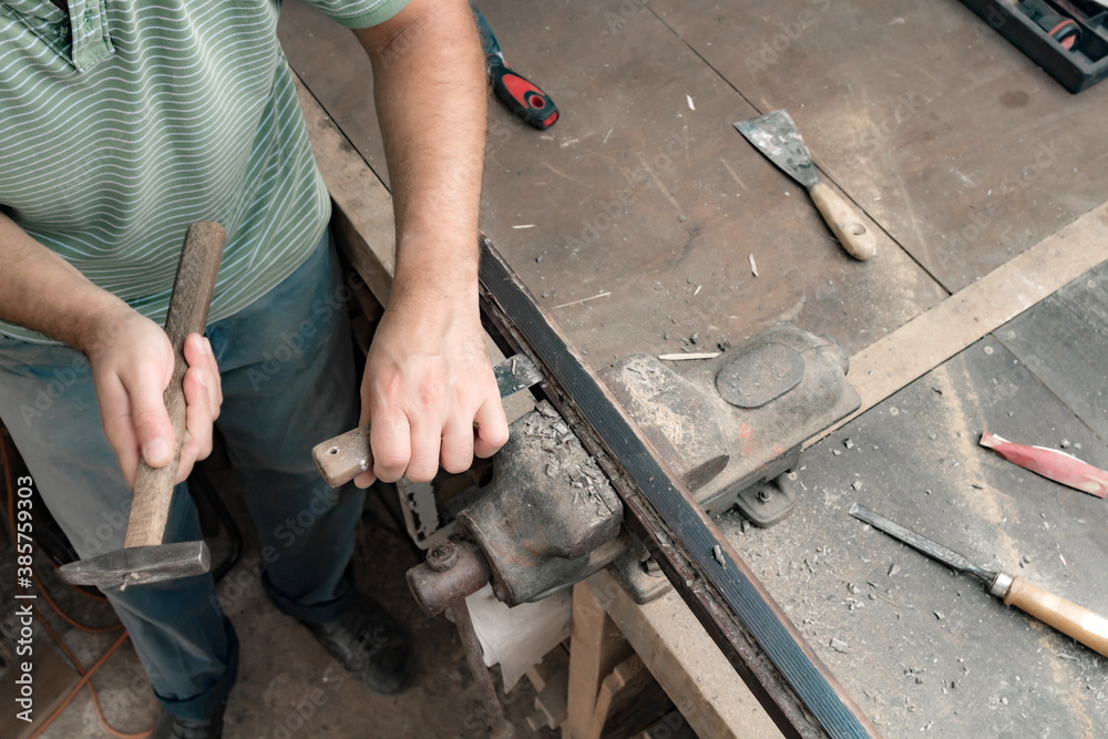 Male carpenter working on old wood in a retro vintage style.