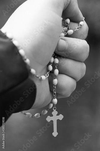 The hand of a man firmly gripping the rosary.