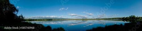 Panoramic view of a calm lake on a sunny summer day