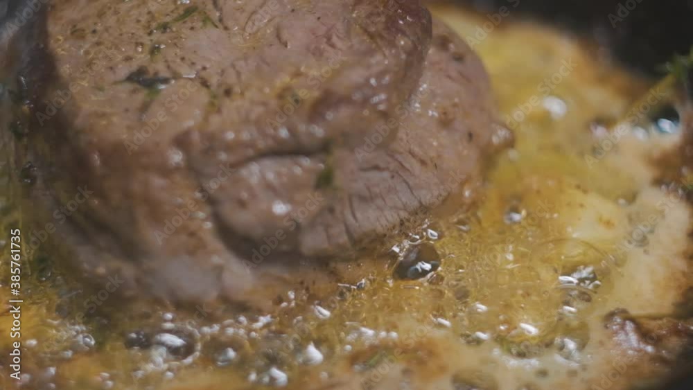 steak cooking in a skillet close-up boiling oil slow motion steak cooking in a skillet close-up boiling oil slow motion
