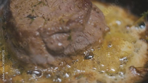 steak cooking in a skillet close-up boiling oil slow motion