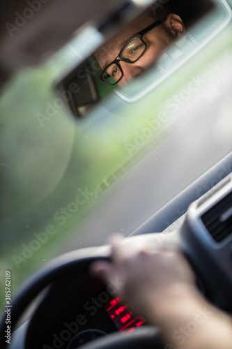 Принти на полотні Handsome young driver driving hic car fast yet safely on the road