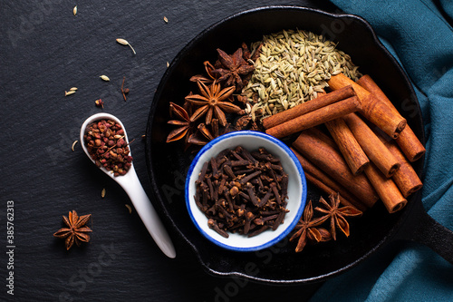 Fototapeta Naklejka Na Ścianę i Meble -  Food concept origin Chinese Five Spice  Star Anise, Fennel Seeds, Szechuan Peppercorns, Whole Cloves and Cinnamon Stick on black rustic background with copy space
