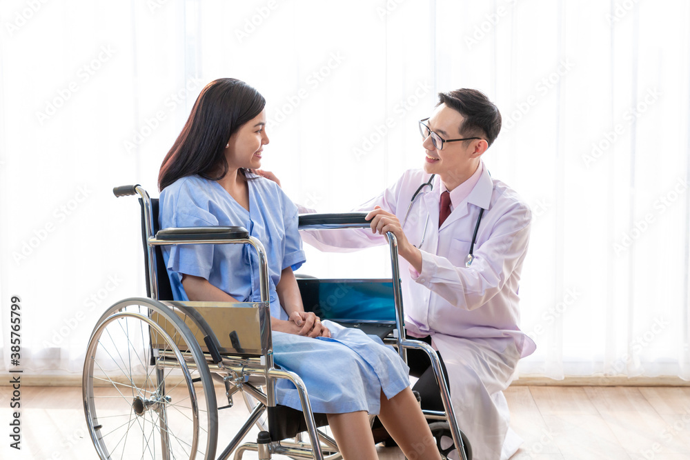 Doctor talking to woman in wheelchair after surgery. Doctor consulting, encourage patient about treatment before discharging from hospital. Medicine, Age, Health Care and People concept, Covid19.