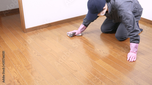 部屋の床にワックスを塗る女性