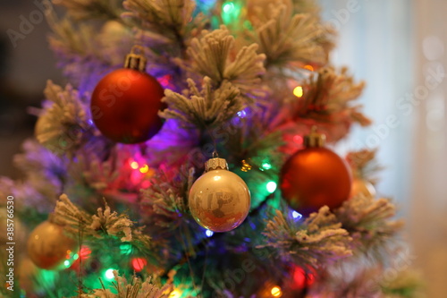 Die bunten und verschwommenen Lichter eines kleinen und weißen Weihnachtsbaumes stehend auf einem roten Tuch.
