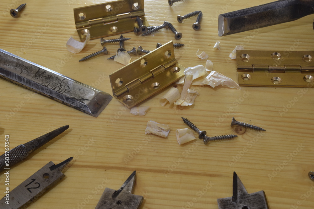 cardine in ottone. Cerniera su di un tavolo da falegname insieme ad altri attrezzi di lavoro per il legno