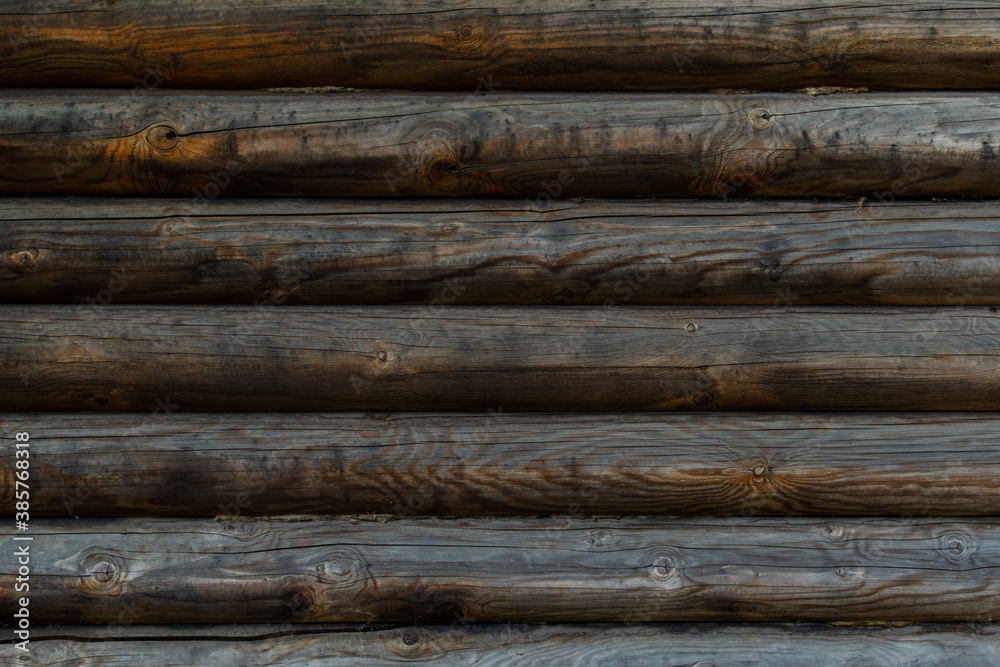 Old wooden brown gray wall made of round logs. Texture background. Russian building Old wooden brown gray wall made of round logs. Texture background. Russian building