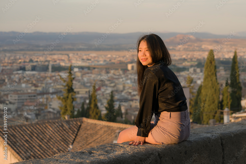 lifestyle portrait of young beautiful and happy Asian Chinese tourist woman enjoying Summer holidays in Europe walking cheerful visiting beautiful Alhambra in Granada Spain
