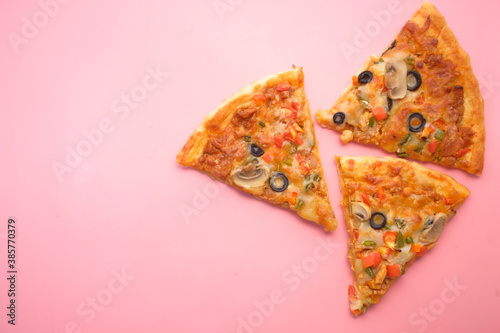 Slice of cheese pizza on a plate on pink background .