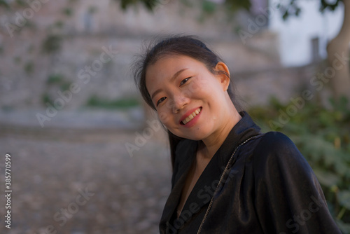 lifestyle portrait of young beautiful and happy Asian Japanese woman enjoying Summer holidays in Europe walking cheerful at Spain Andalusia village in tourism and travel concept