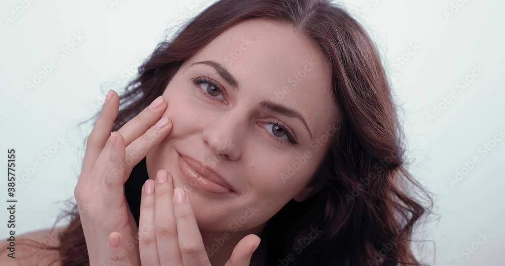 Woman gently touches the skin of the chin with his fingers lightly tapping with the pads of the fingers on the skin of the face applying the cream. High quality 4k footage Woman gently touches the skin of the chin with his fingers lightly tapping with the pads of the fingers on the skin of the face applying the cream. High quality 4k footage