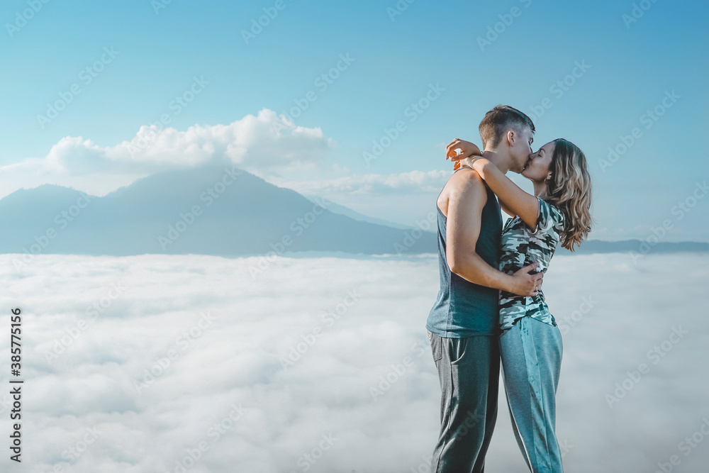 Young Couple Kissing On Top Of The Mountain