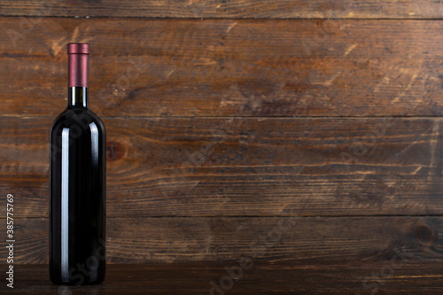 Wine bottle on wooden background. Space for text.