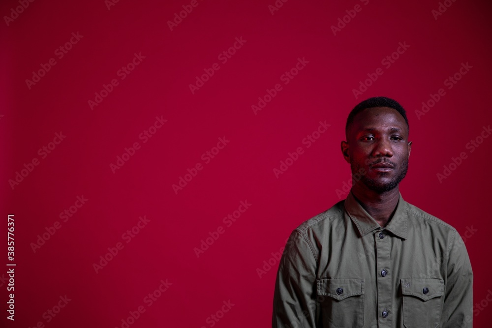 Obraz premium Young Black Man Posing in Studio on Isolated Red Background