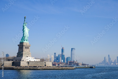 Statue of Liberty in NY Harbor on bright sunny day with blue sky and Manhattan in the distance © Gerald Zaffuts