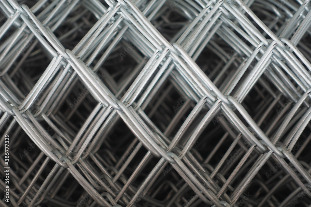 Industrial rolls of aluminum chain link fencing.close up steel wire net texture for background.Rolls of steel wire mesh for use of fencing.Close up of wire mesh fence in roll Industrial rolls of aluminum chain link fencing.close up steel wire net texture for background.Rolls of steel wire mesh for use of fencing.Close up of wire mesh fence in roll