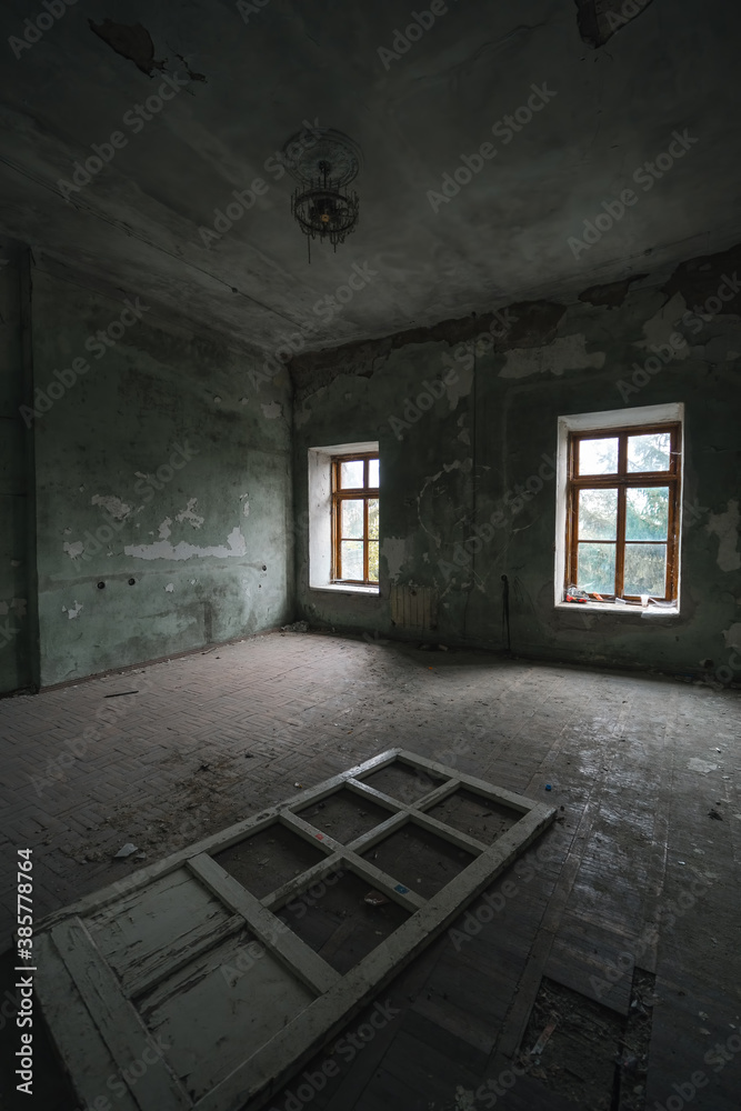 interior of an old abandoned rooms, a lot of garbage, old furniture and antiquities destroyed, rooms need repair, old dust and dirt windows, door. vertical photo