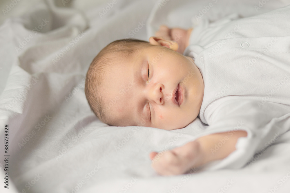 Sleeping newborn baby in a wrap on white blanket. Beautiful portrait of little child girl, one week old. Sleeping newborn baby in a wrap on white blanket. Beautiful portrait of little child girl, one week old.