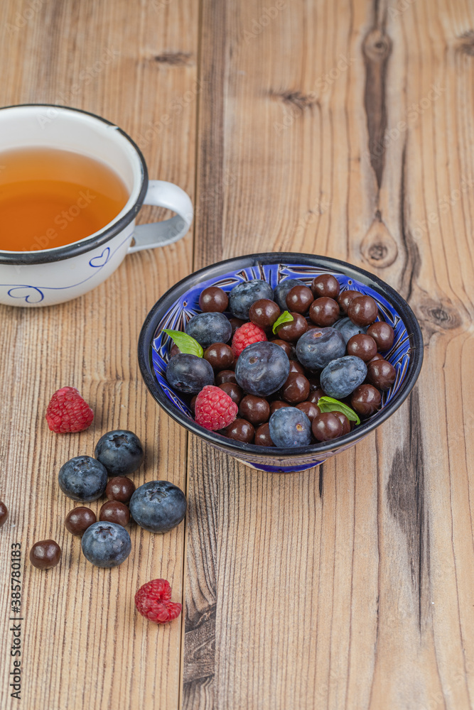Blackberries coated with milk chocolate in a blue ceramic bow