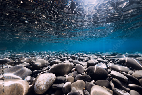 Underwater sea with stones  reflection and blue clear water. Ocean texture