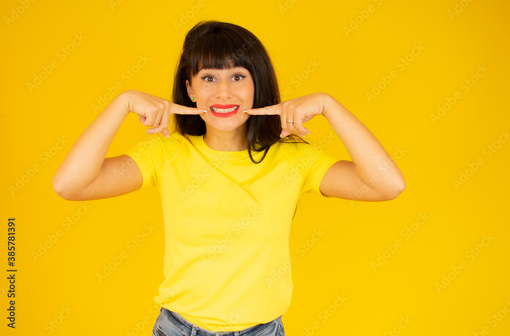 Young woman wearing casual t-shirt over isolated background smiling confident showing and pointing with fingers teeth and mouth. Health concept. Young woman wearing casual t-shirt over isolated background smiling confident showing and pointing with fingers teeth and mouth. Health concept.