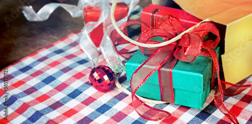 Close up green gift box with red ribbon in shopping bag on the table 