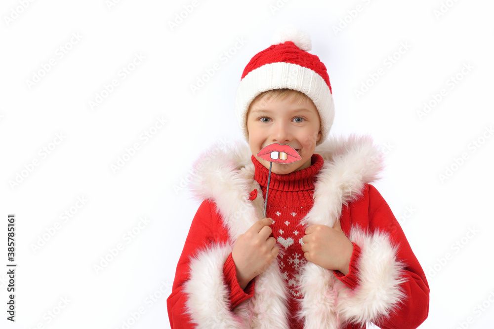 A child dressed as Santa Claus holds a funny lips on a stick prop. A child dressed as Santa Claus holds a funny lips on a stick prop.